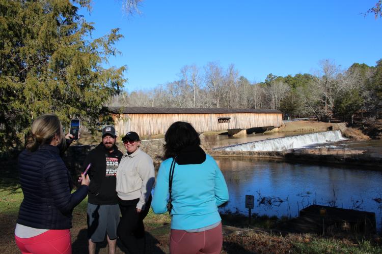 Folks snap photos of each other at Watson Mill Bridge State Park on New Year’s Day. About 92 people showed up for the park’s annual First Day Hike, three times more than last year. (Dakota Meeks/The Oglethorpe Echo)