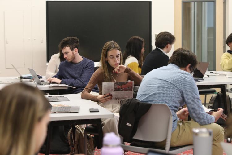 Avi Young (from left), Kayla Lopez and Zeke Palermo read copies of The Oglethorpe Echo during class last January. An AI grant will be used to create specific tools to assist future Echo students. (Grady College)