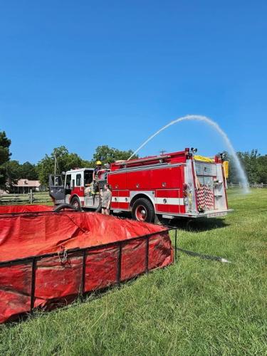 Firefighters from the Vesta Volunteer Fire Department demonstrate how to use the tankers and pools during a training session. The tankers help firefighters throughout the county fight fires where there’s a shortage of hydrants. (Photo submitted by Mike Moravek.)