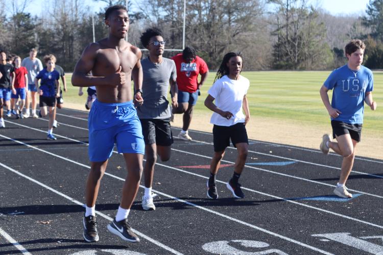 Ke’Mauri Brown (left) and his OCHS track teammates warm up  during a practice last week. Brown hopes to PR in the long jump and  help the Patriots reach state this spring. (Photo/Kayda Hammock)