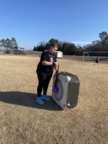 Eighth grader Serenity Curry removes her arrows from a 40-meter target at practice at the OCMS soccer fields on Feb. 9. Curry practices for the state archery match on May 3 at the Rock Eagle 4-H Center. (Photo/Anna Izquierdo)