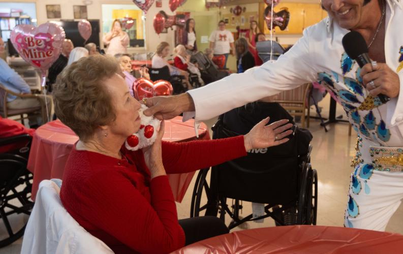 Geneva Stamey shares an exchange with Elvis tribute artist E.J. Boyer as he hands her a teddy bear at Quiet Oaks Nursing Home in Crawford, Ga on Feb. 14, 2025. Stamey is Oglethorpe County's former Clerk of Court, and came to visit Quiet Oaks during their annual Valentine's day event in order see Elvis. (Photo / Lux Corrona)