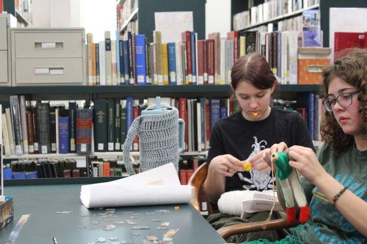Idgie Sullens (left) and Charlotte Jones knit at the Oglethorpe County Library on Friday, Feb. 28. Jones and Sullens have been crafting for over three years, teaching themselves to knit and crochet as a hobby. “I mostly make them for me,” Jones said. “I have, like, a whole shelf in my studio where I put them all, and it's a tree house.” (Photo/Emily Slepsky)