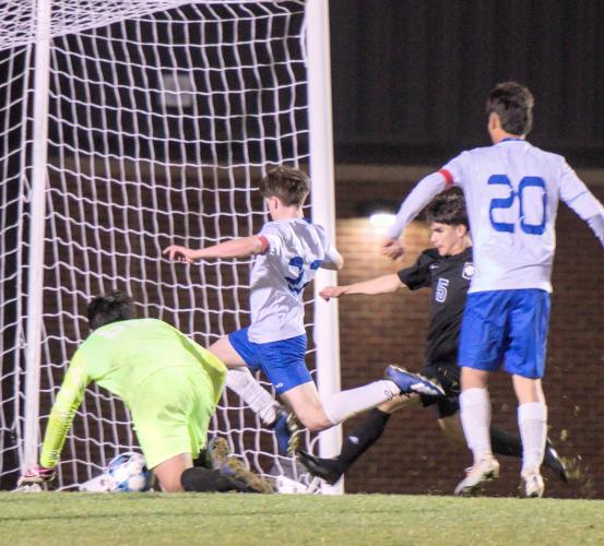 Clint Graham (white jersey going toward goal), a junior forward, leads the OCHS boys soccer team with 12 goals. He wants to reach 15 goals this season. (SUBMITTED PHOTO)
