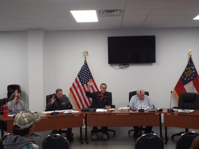 During last Thursday night's Arnoldsville Council meeting, Joyce Sniff, Blake Arnold and Joel Kriner raised their hands to vote. The council unanimously approved an increase in utility fees to help cover rising infrastructure maintenance costs. (Photo/Luis Vaquero)