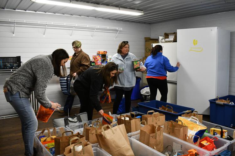 Volunteers with the CAYA House pack donation bins and refrigerator bags ahead of the nonprofit's February delivery. The organization delivers to an average of 10 families a month around Oglethorpe County. (Photo/Jennifer Xia)