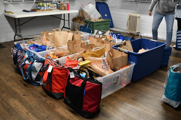 Fully packed donation bins and refrigerator bags sit ready to be loaded into cars for the CAYA House's February delivery. Local Oglethorpe County community members donate food staples and household essentials to provide monthly donations for families in need. (Photo/Jennifer Xia)