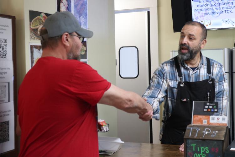 Co-owner Willie Torres shakes hands with Branson McDonald, a first-timer at Town and Country Kafe, on Feb. 26. Many customers aren’t familiar with the cafe and find it in online searches, Torres said. (ADRIANA CASCIO/THE OGLETHORPE ECHO)