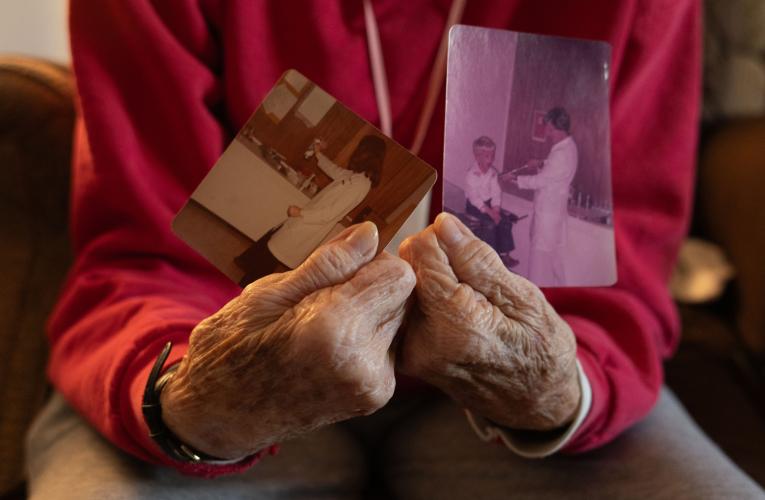 Judith Paul, 85, holds two photos inside her home in Oglethorpe County, Georgia on March 27, 2025. The photos are located inside Oglethorpe Primary Health Care Center, the first ever healthcare facility to open in Crawford, Georgia in 1979. They depict Anne Cummings, the center's first nurse practitioner, and her son, Jay Paul, who is recieving an examination from her. (Photo / Lux Corrona)