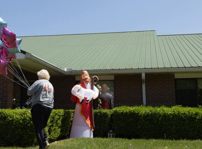 Joann Wrenn carries a bundle of balloons used to decorate Quiet Oaks Nursing Home in Crawford, Georgia for their annual Easter egg hunt with families, residents, and Cub Scout Pack 377 from Comer, Ga on April 13, 2025. Joann Wrenn is the wife of Quiet Oaks administrator Chris Wrenn, and is herself the administrator of Madison Health and Rehab, the sister facility of Quiet Oaks. (Photo / Lux Corrona)