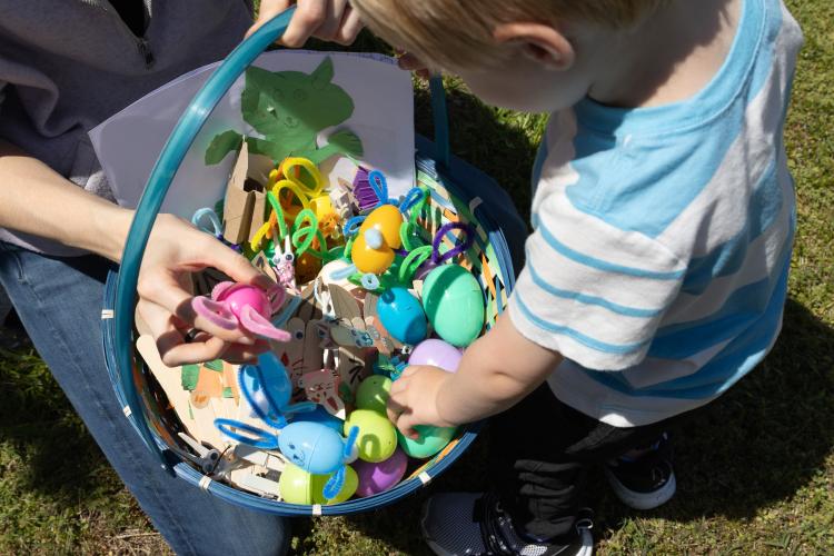 Elliott Davis (2) and his mother Braden Davis look through a basket of Easter eggs decorated by Cub Scout Pack 377 of Comer, Ga at the annual Easter Egg hunt hosted by Quiet Oaks Nursing Home since 1992 on April 13, 2025. The eggs were made for residents of Quiet Oaks, as part of the scouts' community outreach. Braden Davis is Scout Troop Den Mother of Pack 377, and Elliott Davis is a "Dragon Scout," a common nickname used for children of Cub Scout Leaders who are not yet old enough to participate in the tr