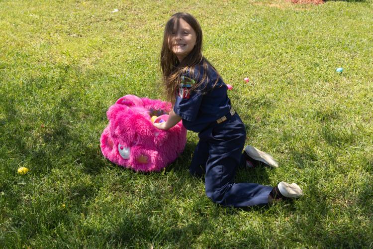 Cheyenne Harbert (6) poses for a portrait as she loads her pink Easter basket with eggs during the annual Easter egg hunt hosted by Quiet Oaks Nursing Home since 1992 in Crawford, Ga on April 13, 2025. Harbert wears her Cub Scout Pack 377 uniform. This is her second year as a Cub Scout. (Photo / Lux Corrona)