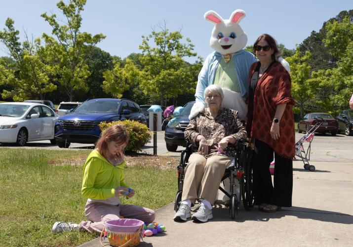 Ginger Free poses for a portrait with her grandmother, Shirley Strickland, and the Easter Bunny at Quiet Oaks Nursing Home in Crawford, Ga on April 13, 2025. Next to them sits Free's daughter, Kaidyn Free, who sorts through Easter eggs she collected during Quiet Oaks' annual Easter egg hunt.