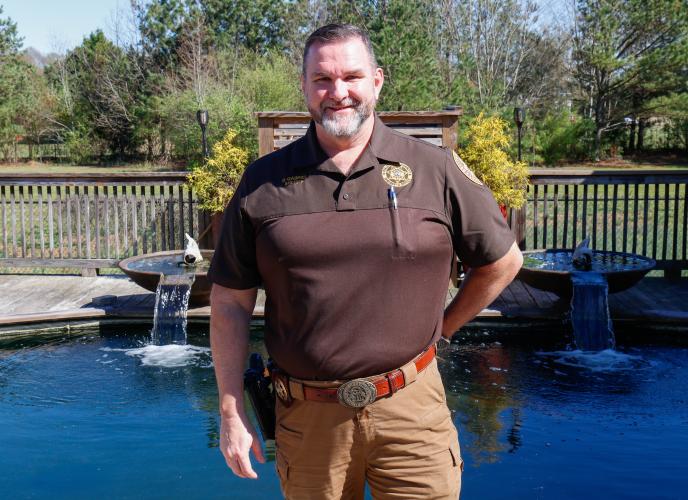 Sheriff David Gabriel poses for a portrait in front of the upper koi pond with his backyard on Monday, March 17, 2025. Even as a child, Gabriel had a love of observing fish and wildlife. “We had a creek we’d stop up, dam the creek up. We’d get brim and catfish and stuff and put it in the creek, you know, and then a storm would come through and blow the dam out, and that would be that,” Gabriel said. (Photo/Felix Scheyer)