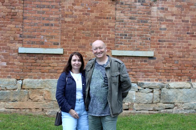 Ivan Vlasov and his wife, Olga Vlasova, pose in front of the Oglethorpe County Historic Jail on Saturday, April 12. The couple is passionate about history and had eagerly awaited the opening to document it on their YouTube channel. (Photo/Emily Slepsky)