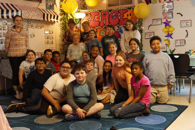 Gwendoline Browning poses with Kathy Mercer's fifth grade class after her presentation on her evacuation during World War II at Oglethorpe County Elementary School on Friday, March 28, 2025 in Lexington, GA. Browning's grandson is a member of the class and invited her to speak after they had finished reading a historical fiction novel based on events that happened during her childhood. (Photo/Frankie Hennessy)