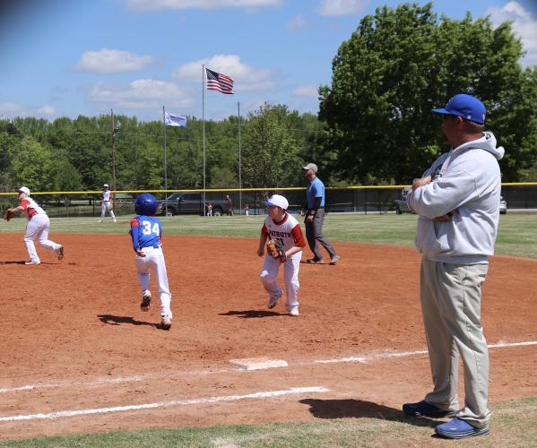 Michael White stands near first base as center fielder Easton Adams heads toward second and Rusch White looks to cover first at Bryan Park on Saturday. Chad Stites, father of Adams, said his son thought it was “cool” to split up the teams and play with other teammates. (Photo/Anna Izquierdo)