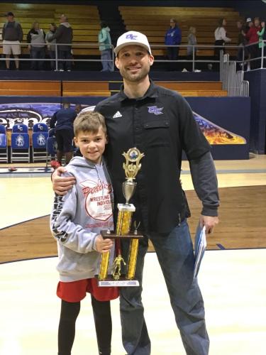 Miles Mason stands with his dad, Steve Mason, after a wrestling match. Steve coached Miles for five years of his career. (Submitted photo)