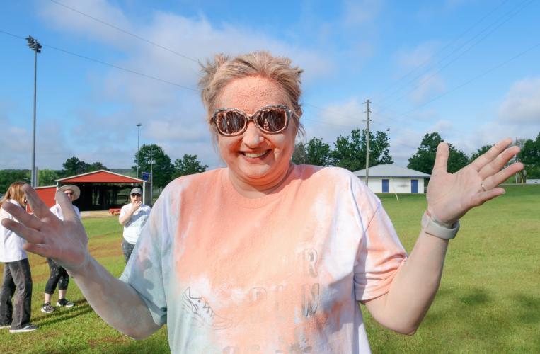 Alicia Dellinger, an economics teacher at Oglethorpe County High School, poses for a portrait after finishing the Oglethorpe County High School Color Run course at the Oglethorpe County High School in Oglethorpe County, Georgia, on Saturday, April 26, 2025. A majority of the chalk spread across Dellinger came from members of NHS who had her as a teacher, alongside her son Aidan Dellinger. (Photo/Felix Scheyer)