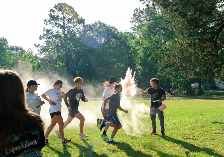 Aydan Aziz, a sophomore student at Oglethorpe County High School, throws chalk at a runner as they cross the start line behind the gym of the Oglethorpe County High School in Oglethorpe County, Georgia, on Saturday, April 26, 2025. After beginning the run, participants would run or walk approximately 1.5 miles along the high school’s cross country course. (Photo/Felix Scheyer)