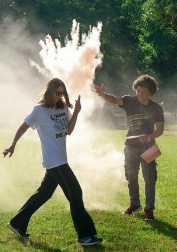 Aydan Aziz, a sophomore student at Oglethorpe County High School, throws chalk at runners as they cross the start line on Saturday, April 26, 2025. After beginning the run, participants would run or walk approximately 1.5 miles along the high school’s cross country course. (Photo/Felix Scheyer)