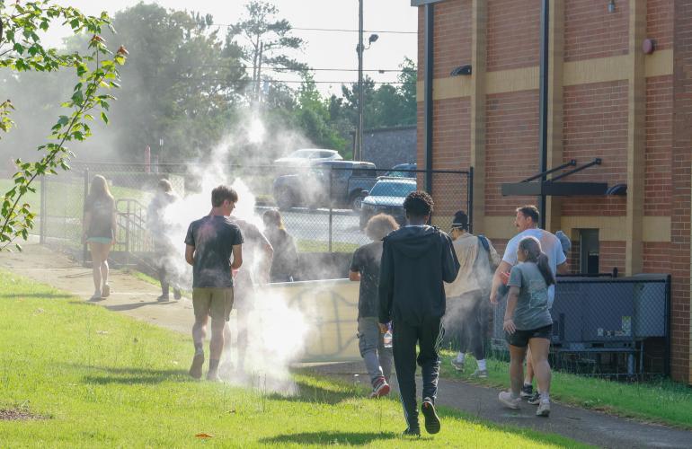 Members of Oglethorpe County High School National Honor Society work together to clean up the area behind the OCHS gym after the Oglethorpe County High School Color Run at the Oglethorpe County High School in Oglethorpe County, Georgia, on Saturday, April 26, 2025. Though the event had ended, colorful chalk continued to fill the air as students continued to empty the remaining chalk within their buckets onto their friends and peers. (Photo/Felix Scheyer)