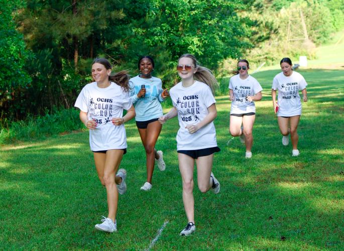 A group of runners move along the course of the Oglethorpe County High School Color Run, running behind the gym of the Oglethorpe County High School in Oglethorpe County, Georgia, on Saturday, April 26, 2025. Each participants paid a $20 entry fee, collected in order to benefit The CAYA House. “[The CAYA House] is always in need of more donations, and as a group, NHS has votes on what charity will represent. So we found it an important one to support,” said Sophia Wilson, a senior student and National Honor