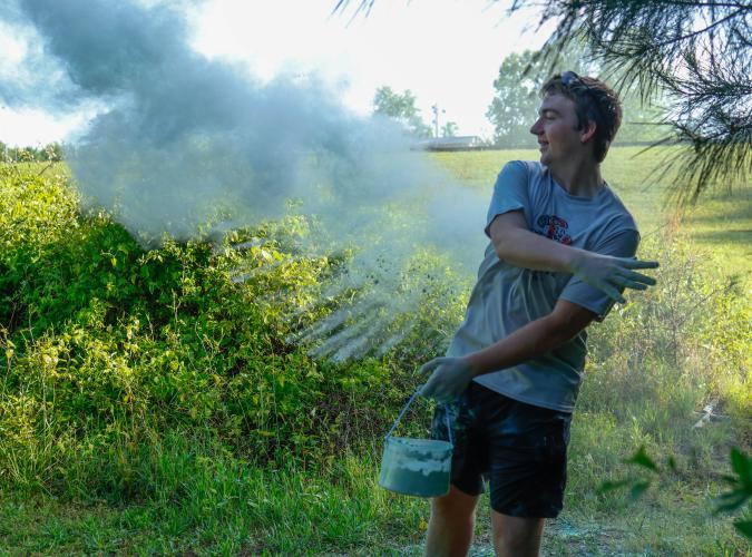Jake Huff, a sophomore student at Oglethorpe County High School, throws chalk at runners as they run along the Oglethorpe County High School Color Run in Oglethorpe County, Georgia, on Saturday, April 26, 2025. Though the chalk kept blowing back into his face, Huff was excited to be able to participate in the Color Run while raising funds for The CAYA House. (Photo/Felix Scheyer)