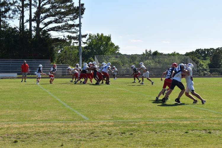 OCHS football players go through spring drills at Patriot Stadium on Tuesday. Head coach Mike Holland expects to see improvement from several returning players this year. (Photo/Emma Greene)