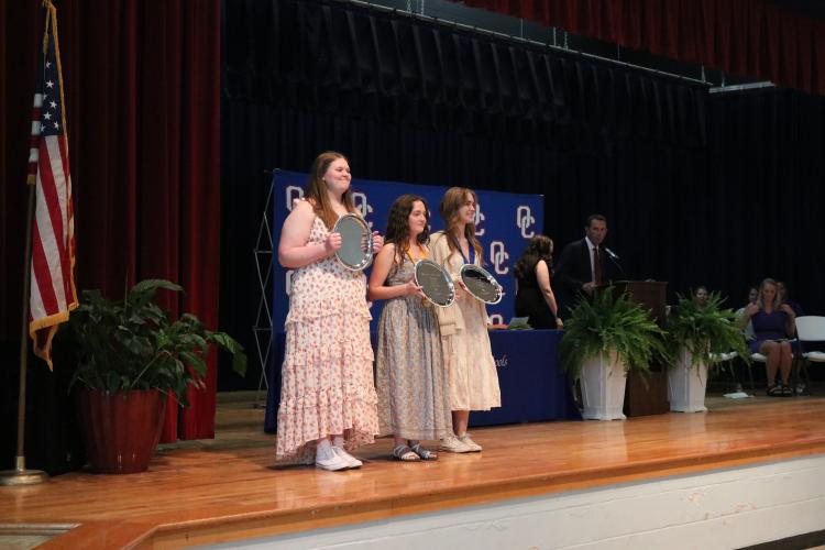 Emily Carter (from left), Alie Duffell and Abby Horton were awarded plates for being named the honorarian, the salutatorian and the valedictorian of the OCHS Class of 2025 on Tuesday. Horton plans to attend the University of Georgia. (Photo/Anna Izquierdo)