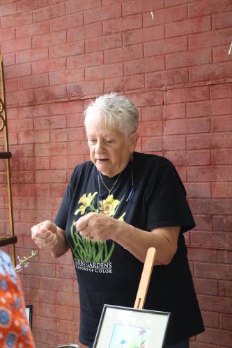Christi Fordyce chats with customers about the types of flowers she painted and the techniques she used for her watercolor drawings that she had for sale at the fourth annual Friends of the Oglethorpe County Library Book and Art Sale last Saturday. The shows are held on the first Saturday in May and November. (Photo/Olivia Wilson)