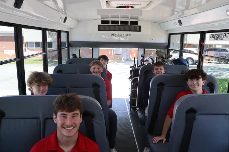 Members of the OCHS boys golf team are ready to head to a tournament in Lincolnton on a school activity bus driven by coach Gary Hughes. Several coaches double as bus drivers for OCMS and OCHS teams. (Photo/Kayda Hammock)