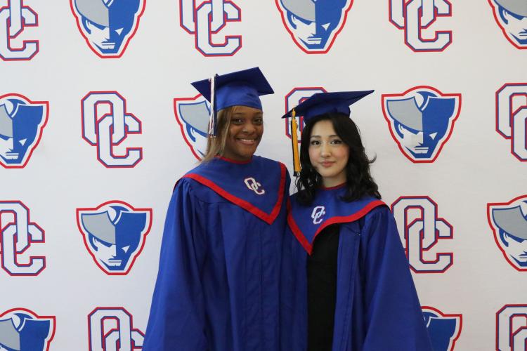 Deandra Jarrett (from left) and Flor Padilla pose for a photo in the OCHS cafeteria prior to graduation last Friday. Jarrett and Padilla were two of the 150 students to receive their diplomas. (Photo/Anna Izquierdo)