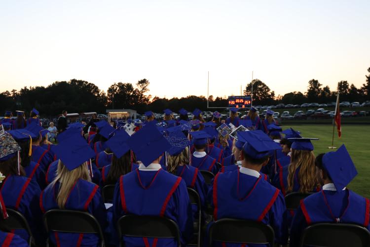 Graduates adorned in blue caps and gowns sit in chairs on the field last Friday before the OCHS graduation ceremony began. Principal Bill Sampson gave the opening speech, reminding students to be kind. (Photo/Anna Izquierdo)
