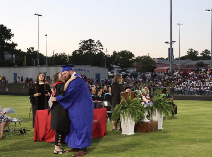 Dylan Anglin hugs OCHS teacher Jessica Tipton after he was awarded his diploma last Friday at Patriot Stadium. Anglin was one of 150 students to graduate with the class of 2025. (Photo/Anna Izquierdo)