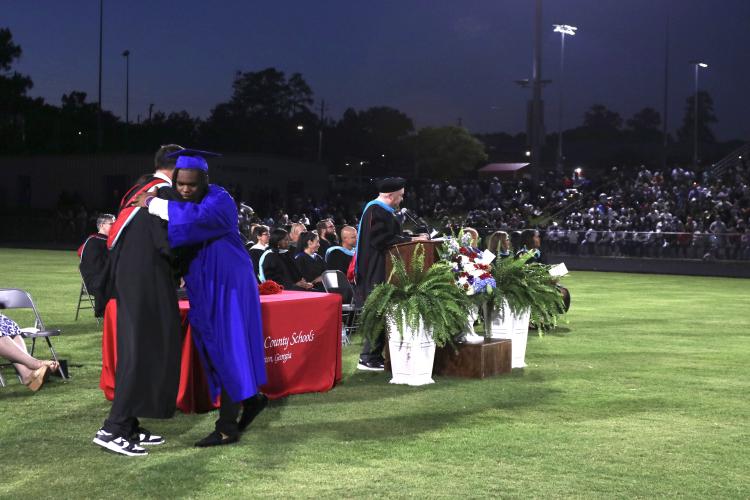 CJ Whitlock hugs principal Bill Sampson after receiving his diploma at OCHS graduation last Friday. (Photo/Anna Izquierdo)