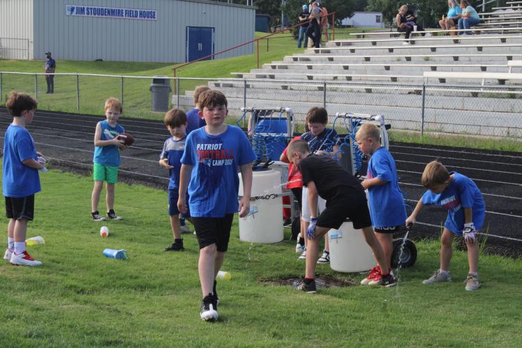 Campers take a water break in between drill exercises at the OCHS Youth Football Camp in Patriot Stadium on Jun. 19. (Photo/Elizabeth Kim)