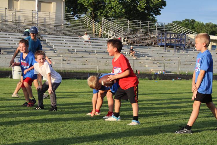 Coach Clint Graham looks on as campers wait for the center to snap the ball during a 7v7 game at the rec department’s youth football camp last week. The camp was for ages 6-11. (Photo/Elizabeth Kim)