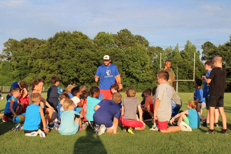 OCHS coach Mike Holland gives his closing remarks to campers at the end of the youth football camp on June 19. Other OCHS coaches at the camp included Web Allgood, Mike Campbell and Josh Austin. (Photo/Elizabeth Kim)