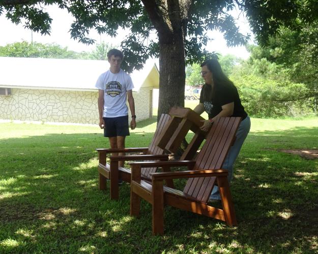 Cory Tillman and Nicole Hensley set up the chairs outside of the Oglethorpe County Library.  This patio set will provide parents with a shady spot  to relax and watch their children play during library events. (Photo/Elizabeth Kim)