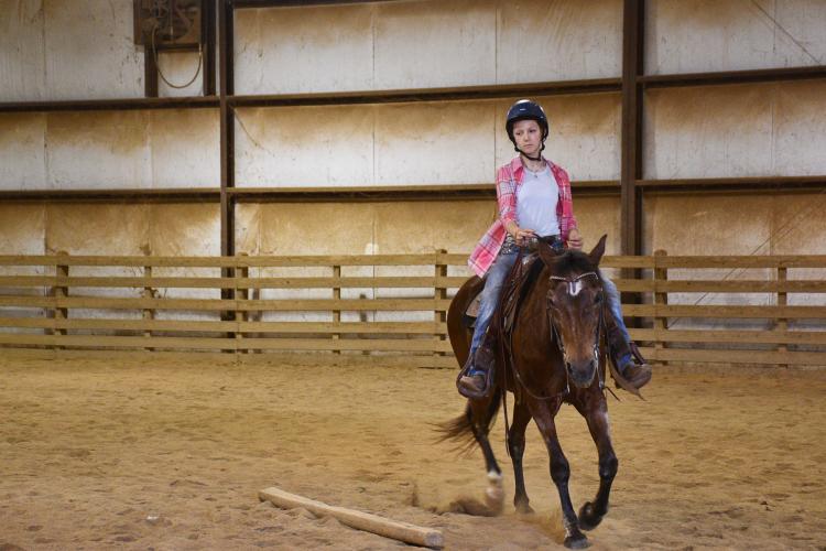 Emma Gabriel, 11, rides her competition horse Gaybars Superstar, or better known as “Bunny,” around her family's Colbert riding arena. (Photo/Jennifer Xia)