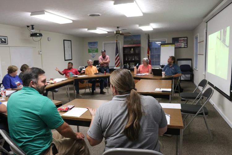 Shanna Reynolds (from front), Oglethorpe County 4-H agent Marcus Eason, superintendent Beverley Levine, administrative assistant Sue Ann Blalock, Guillermo Camacho, Tim Poole, Jake Willcox, Susan Robinson and director of operations Paul Thiel discuss reading and speech services for home school students with disabilities for the 2025-26 school year at a work session Tuesday. (Photo/Anna Izquierdo)