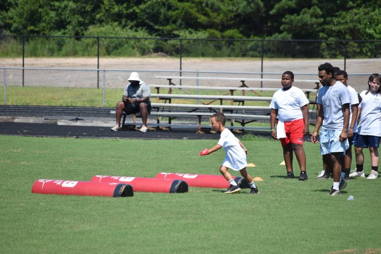 Kids ages 6-16 participated in drills at KB Bonds', former OCHS football player and current defensive lineman, football camp on Saturday. Campers learned new skills from former OCHS and current college players. (Photo/Emma Greene)