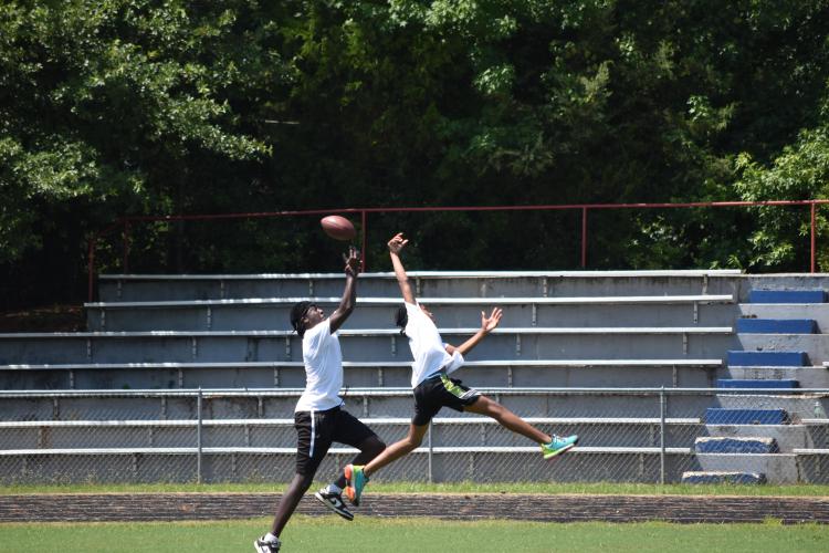 Campers compete for the ball thrown by a staff member on Saturday. The camp staff included OCHS football coaches and college football players. (Photo/Emma Greene)