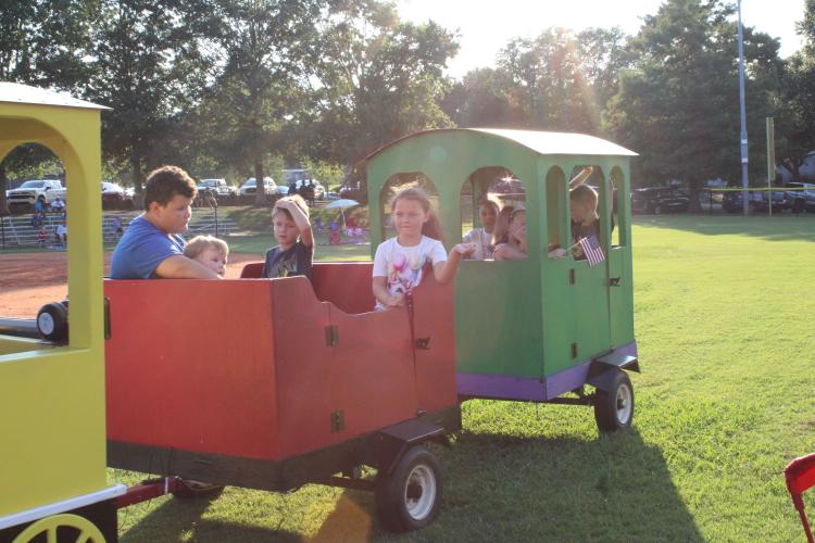 Children enjoy a train ride around the outfield of the baseball field at the 4th of July Celebration at Bryan Park. "It's a really good spot for families to gather," said event organizer Tina White, "and, kids can run all over this field. It's just a good safe spot." (Photo/Elizabeth Kim)