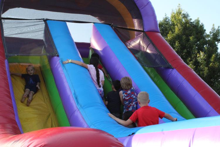 Children race of the ladder of the inflatable slide at the 4th of July Celebration at Bryan Park. "It's a really good spot for families to gather," said event organizer Tina White, "and, kids can run all over this field. It's just a good safe spot." (Photo/Elizabeth Kim)