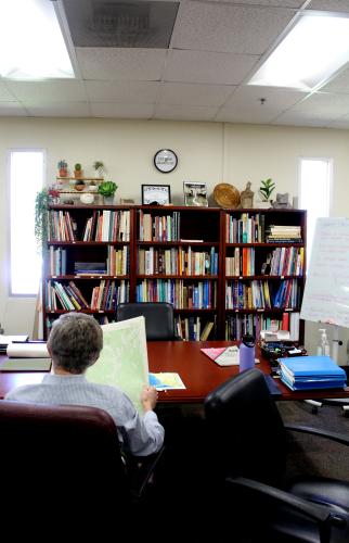 Tom Gresham holds one of the maps detailing Native American sites in Oglethorpe County at UGA’s Archaeological Laboratory this spring. He said the Native Americans in the region lived on farmsteads, which include houses for the extended family. (Photo/Emily Slepsky)
