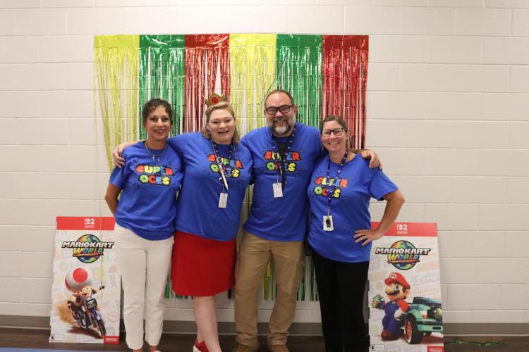 OCES math teacher Mary Ellen Bridges (from left), music teacher Rebekah Poss, STEM teacher Kevin Southall and gifted education teacher Lindsay Gregory stand near the cafeteria and gymnasium during the first day of school on Aug. 1. (Photo/Anna Izquierdo)