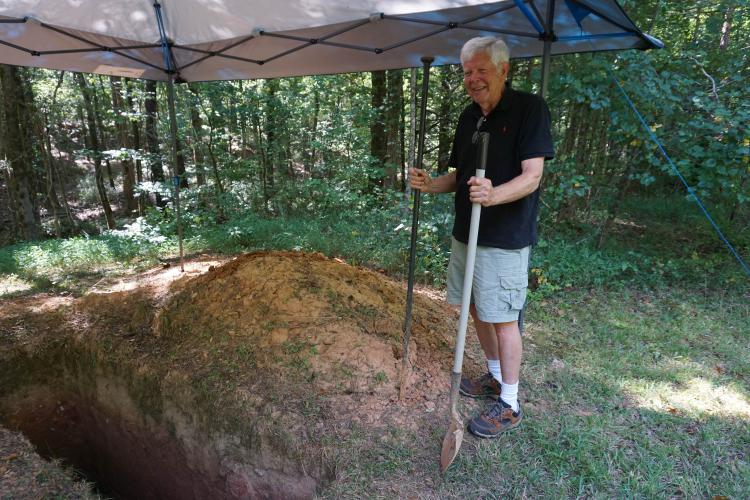 John Fortuna, who is 76 years old, isn’t sick or dying, but said when his time comes he wants to be laid to rest in his hand-dug hole, next to his home in Lexington, wrapped in his mother’s quilt. He covered the grave with a tent during the digging process. (Photo/Alex Perri)
