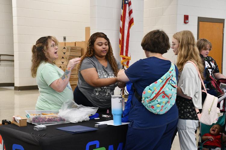 Trish Whatley (left) and Desiree Davis (right) pass out goodie bags to local families at this year's Community Day at Oglethorpe County Middle School. The pair represented Medlink as one of the local healthcare resources for community members in the county. (Photo/Jennifer Xia)